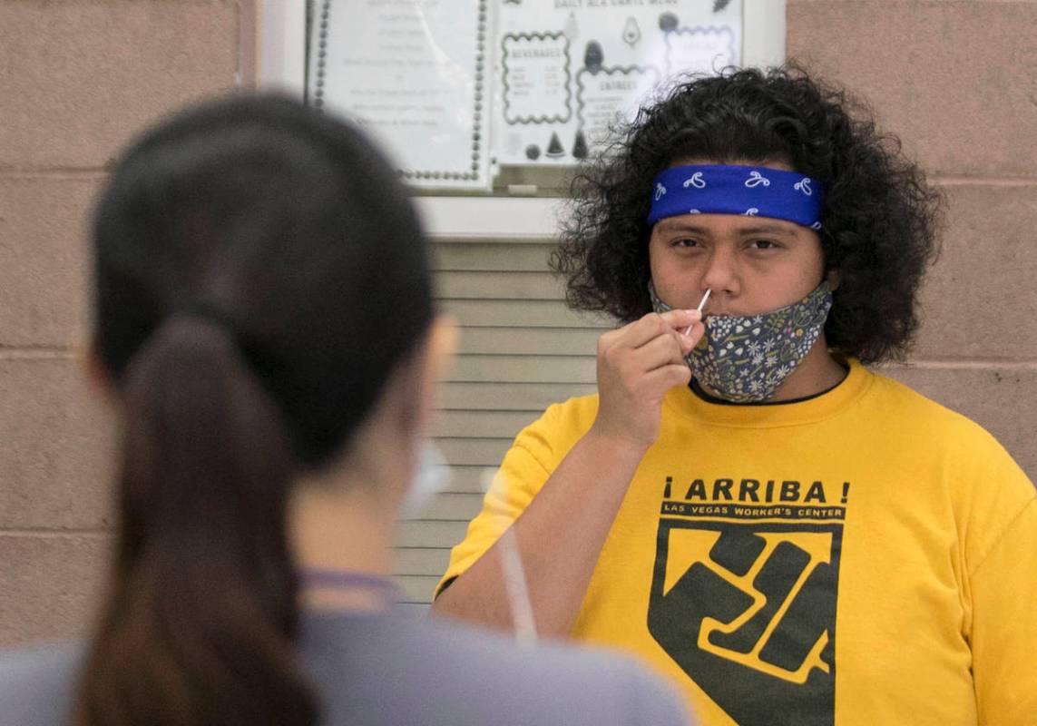 Alondra Contreras, left, a register nurse from Southern Nevada Health District, watches as Urie ...