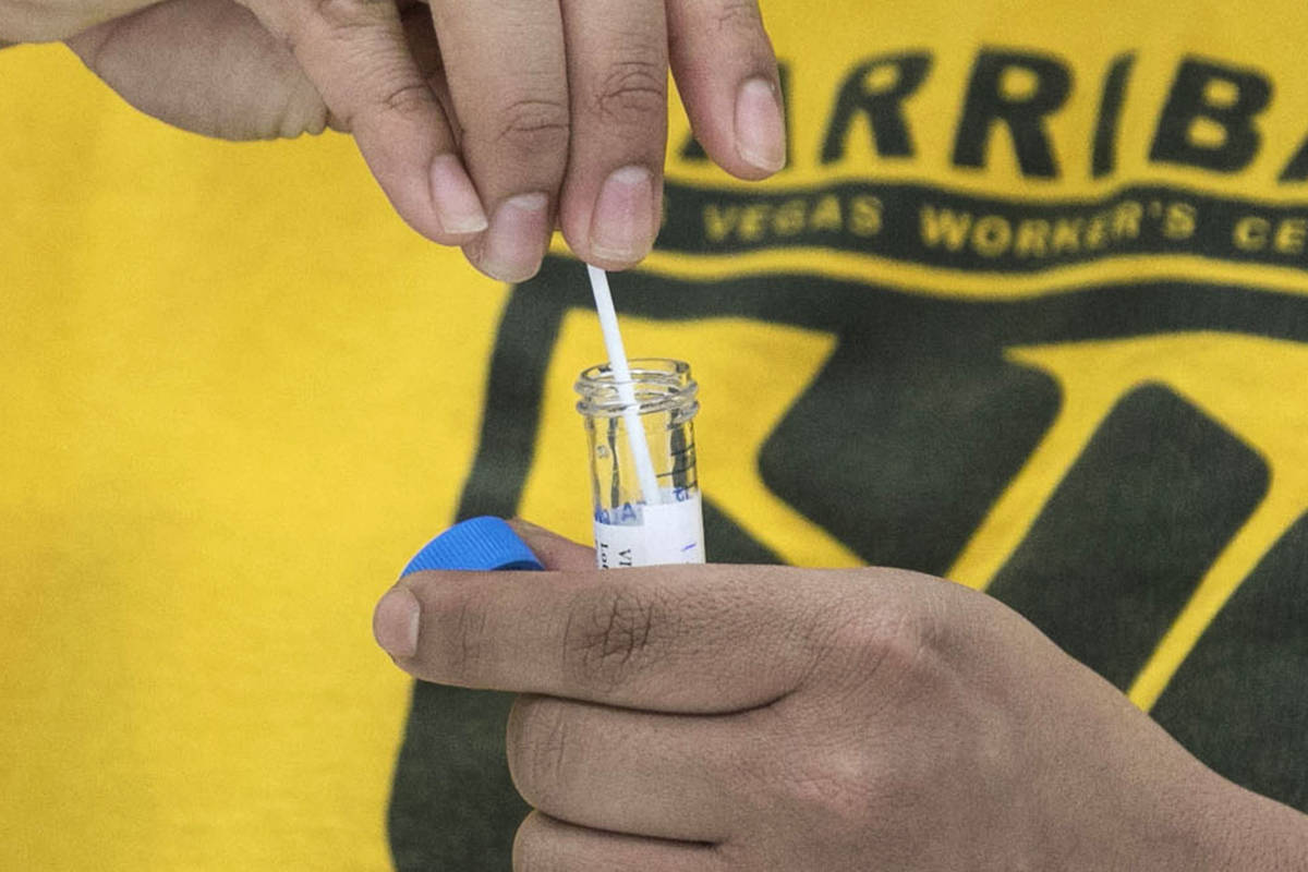 Uriel Guevara-Garcia puts the swab into a tube after conducts self-swabbing test during a commu ...