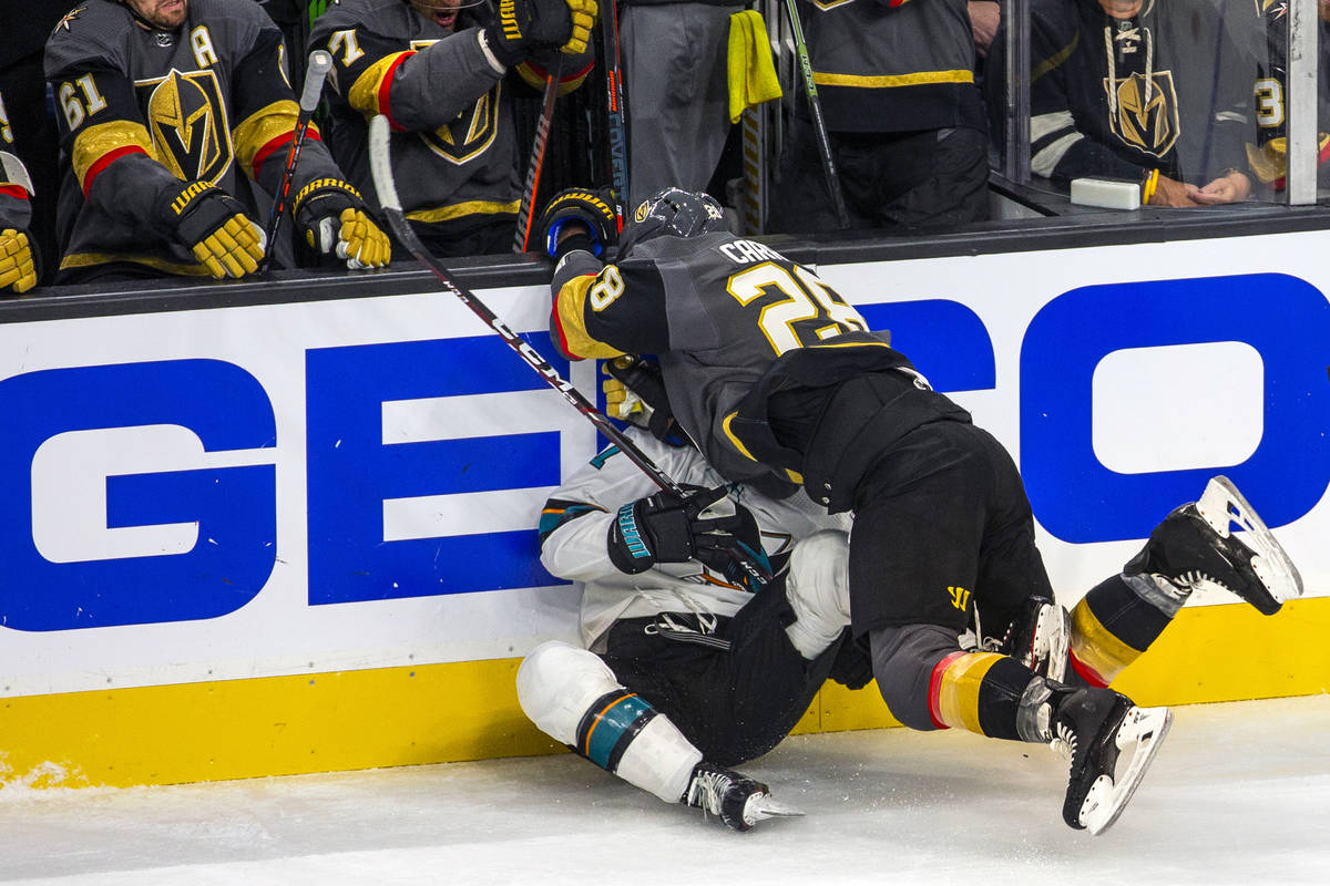 Vegas Golden Knights left wing William Carrier (28) crushes San Jose Sharks center Dylan Gambre ...