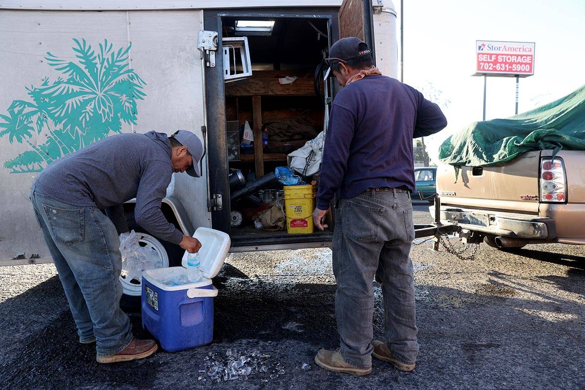 Oscar Orosco, left, Pedro Hernandez load ice for their work day at a kiosk on the corner of Smo ...