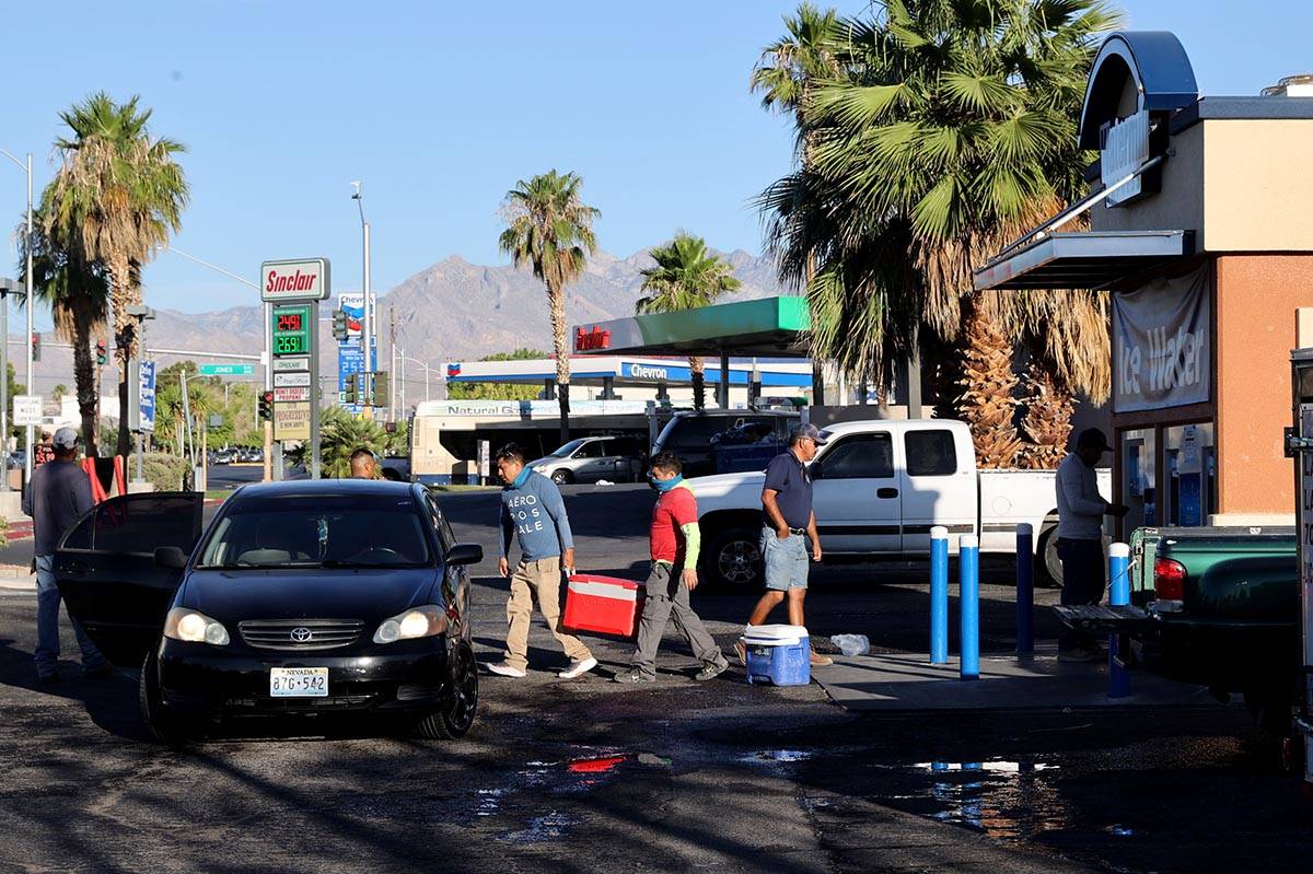 Workers line up for ice at a kiosk on the corner of Smoke Ranch Road and Jones Boulevard in Las ...