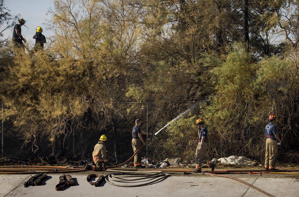 Clark County firefighters extinguish a brush fire in east Las Vegas near the Royal Links Golf C ...