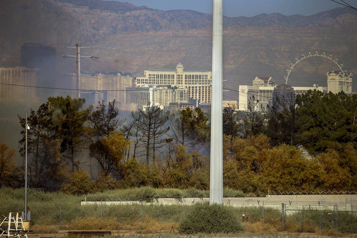 Smoke rises as Clark County firefighters extinguish a brush fire in east Las Vegas near Royal L ...
