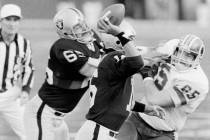 Los Angeles Raiders quarterback Jim Plunkett prepares to pass under pressure as Washington Reds ...