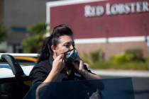 Alexis Cossman puts on her mask before entering work on Tuesday, July 14, 2020, in Las Vegas. C ...