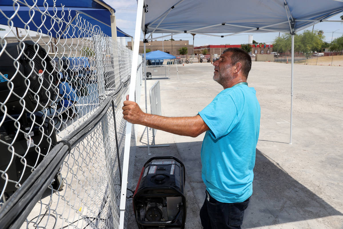 Volunteer Donald Grigsby sets up a canopy over a generator at the Courtyard Homeless Resource C ...