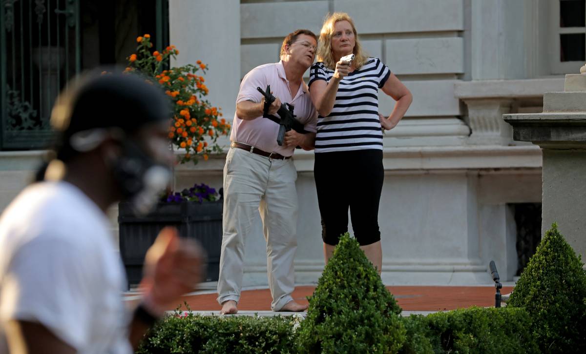 FILE - In this June 28, 2020 file photo, armed homeowners Mark and Patricia McCloskey, standing ...