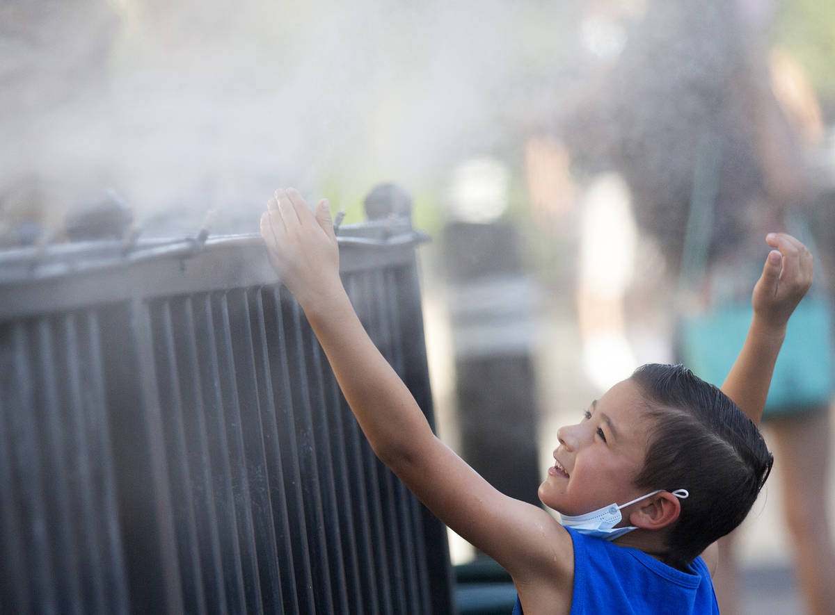 Brody Lester, 5, of California, cools off with the mist from HEXX kitchen + bar's patio as temp ...