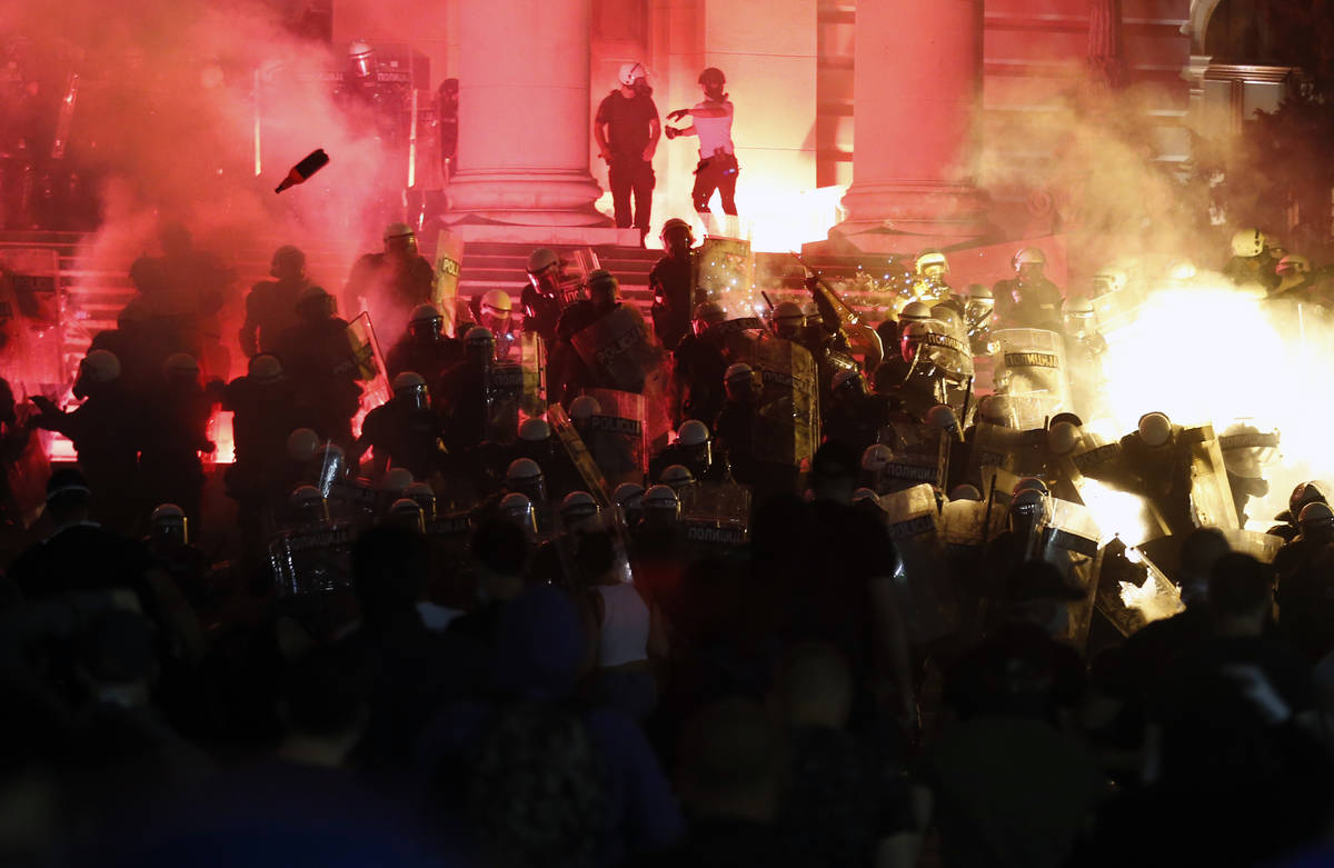 Protesters clash with riot police on the steps of the Serbian parliament during a protest in Be ...