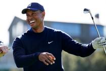 Tiger Woods smiles after hitting his tee shot on the 16th hole during the Genesis Invitational ...