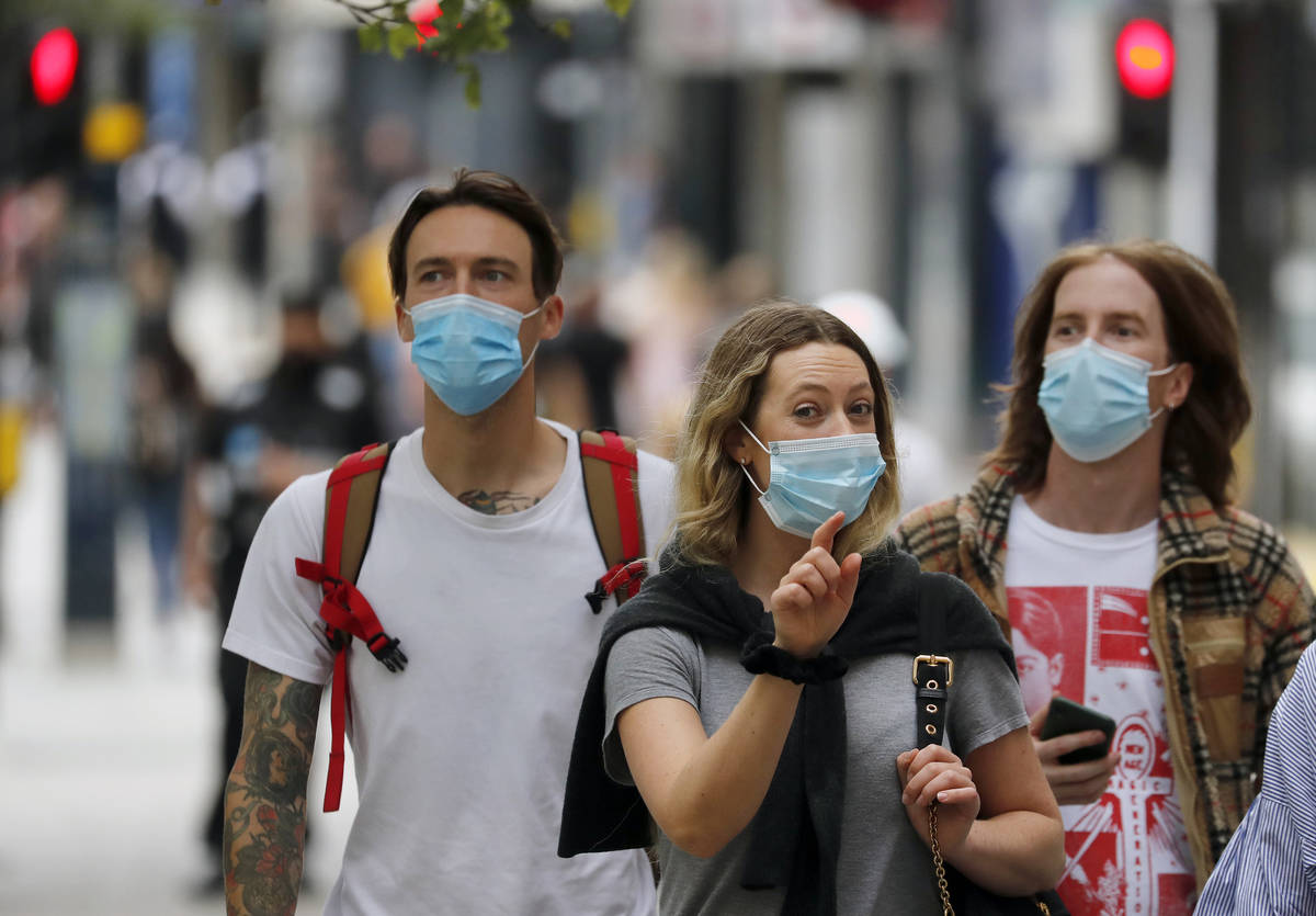 Shoppers wearing protective face masks walk along Oxford Street in London, Tuesday, July 14, 20 ...