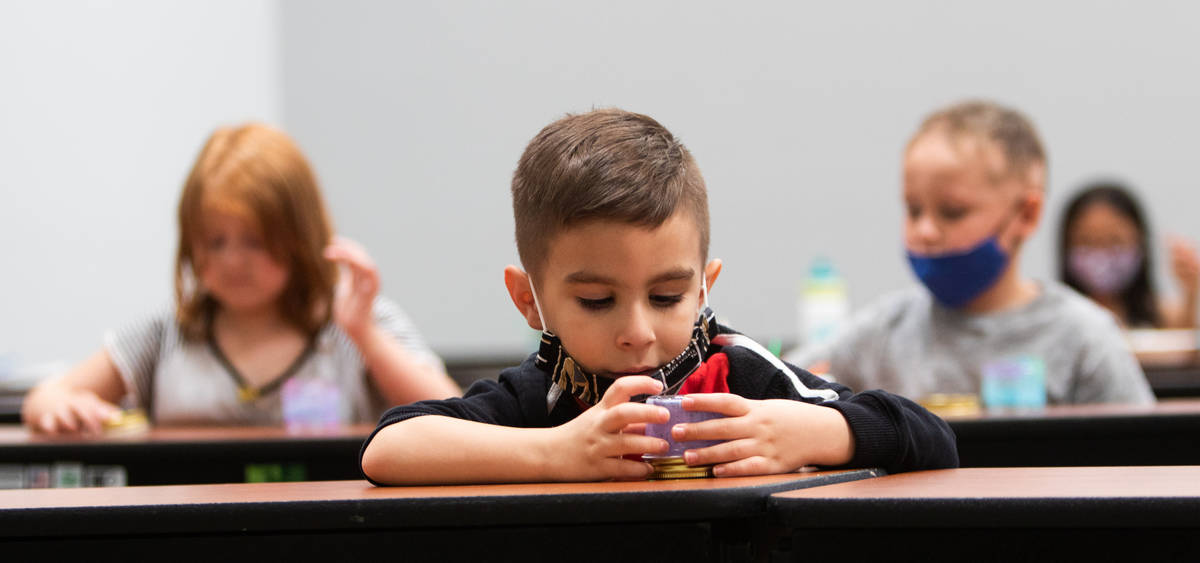 Olivia, 6, from left, Santiago, 5, and Levi, 6, play with paint in the cafeteria during a summe ...