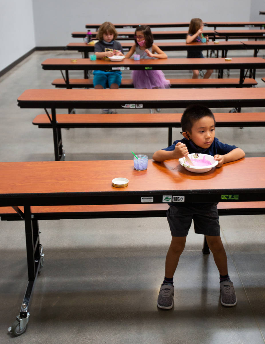 Jason Widjaja-Arief, 6, and other children play with paint in the cafeteria during a summer cam ...