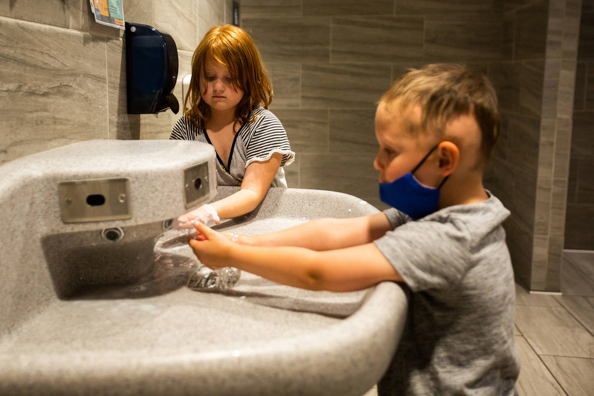 Olivia, 6, and Levi, 6, wash their hands during a summer camp at Legacy Traditional School in L ...