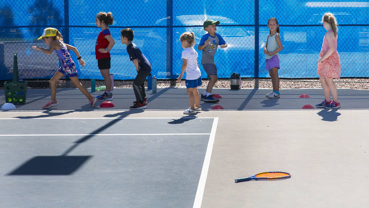 First grade students prepare to run through tennis drills at Camp Mustang at The Meadows School ...