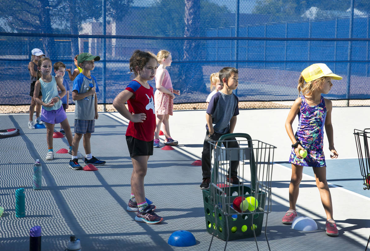 First grade students prepare to run through tennis drills at Camp Mustang at The Meadows School ...
