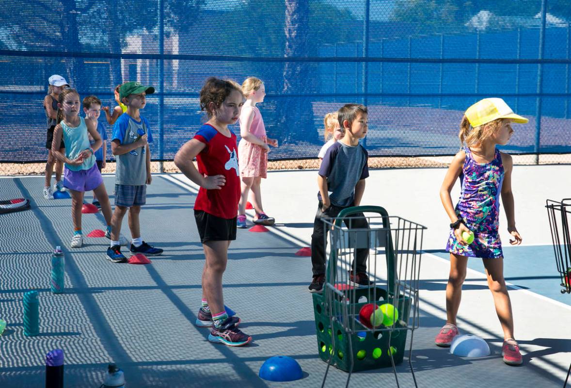 First grade students prepare to run through tennis drills at Camp Mustang at The Meadows School ...