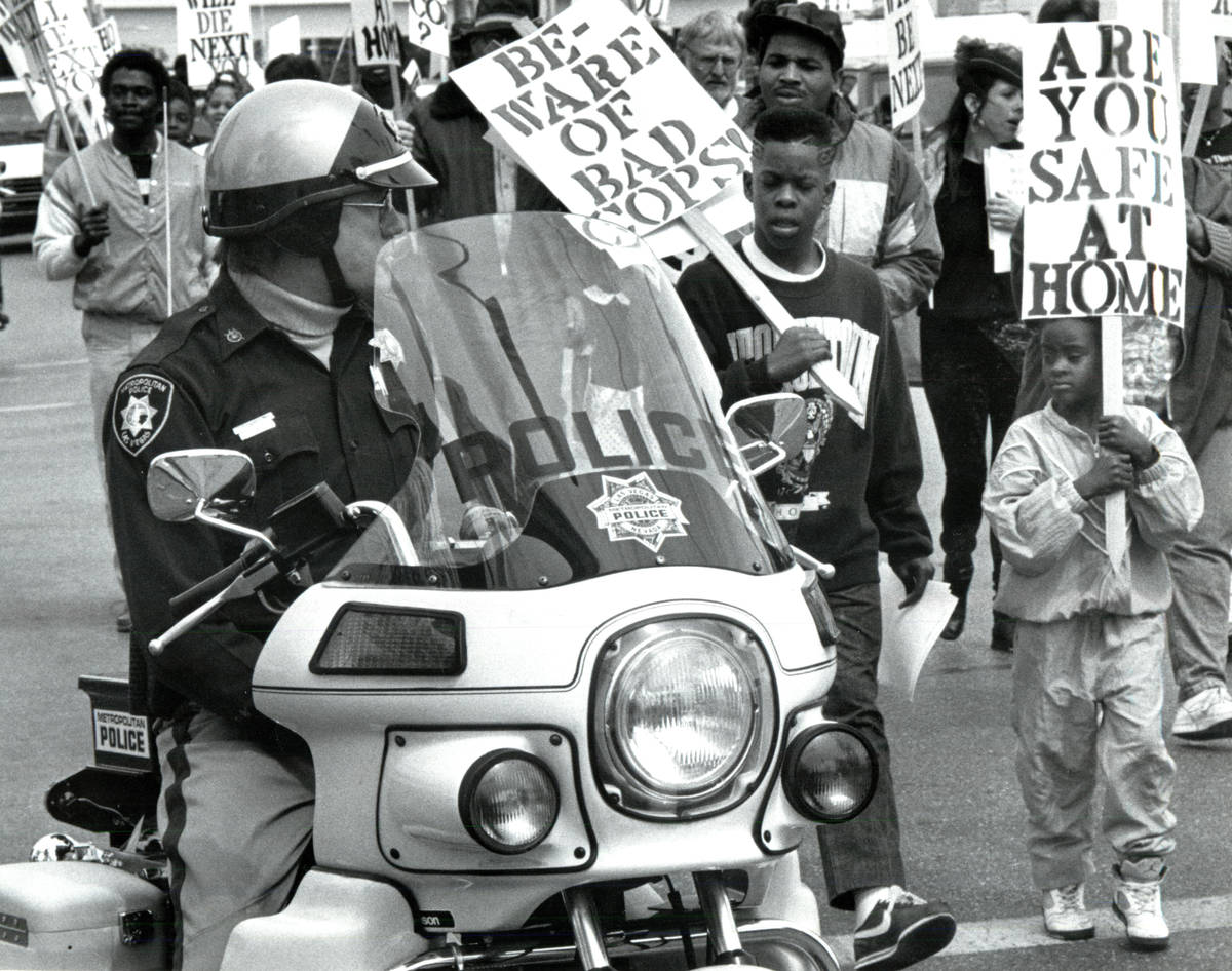 Metropolitan Police Department officers escort marchers protesting Charles Bush's killing durin ...