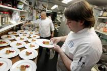 FILE - In this May 11, 2012, file photo, chef and owner Josiah Slone, right, prepares a foie gr ...