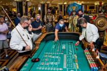 Guest Ben Laparne, center, throws the first dice at a caps table as part of the re-opening cere ...