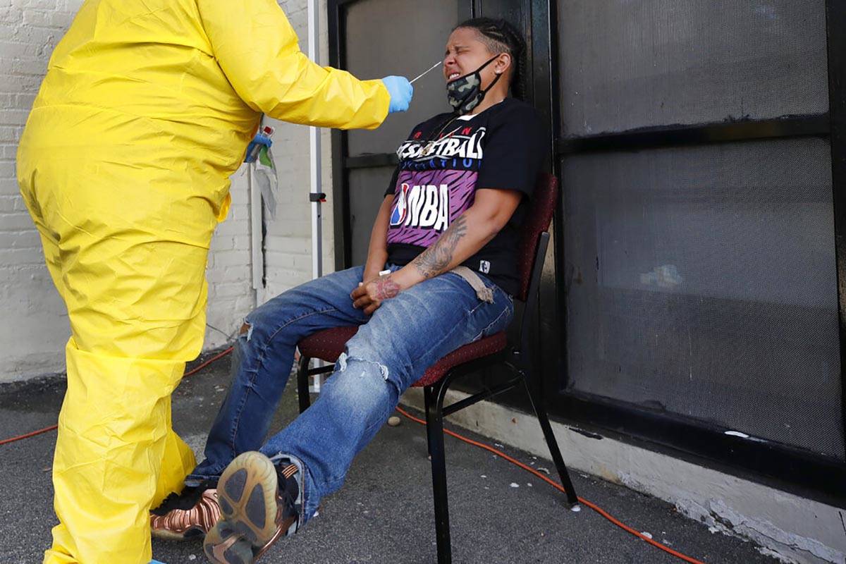 Naliber Tavares winces as she receives a COVID-19 test at the Whittier Street Health Center's m ...