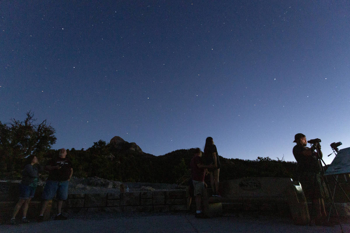 Viewers of the NEOWISE comet watch as it is visible to the naked eye for the last evening on Sa ...