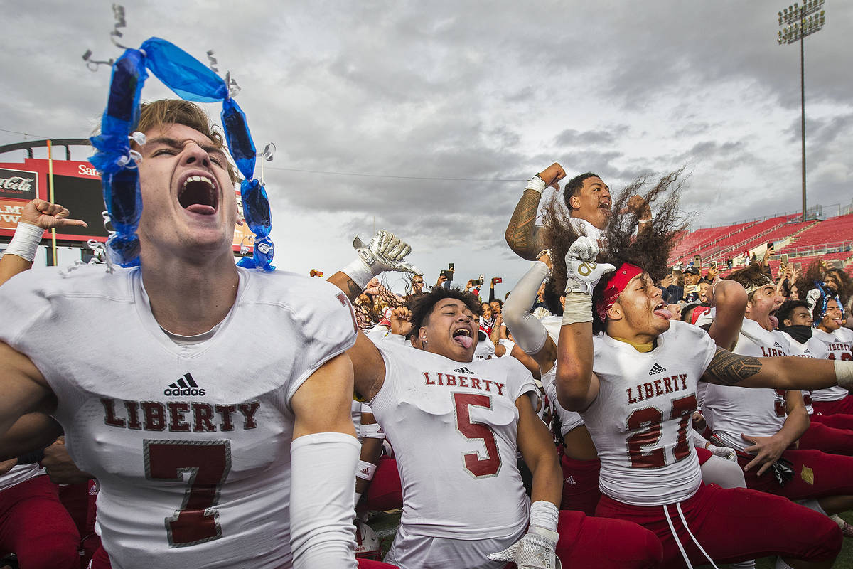 Liberty senior quarterback Kanyon Stoneking (7), celebrates with teammates Ezra Tomhoon (5) and ...