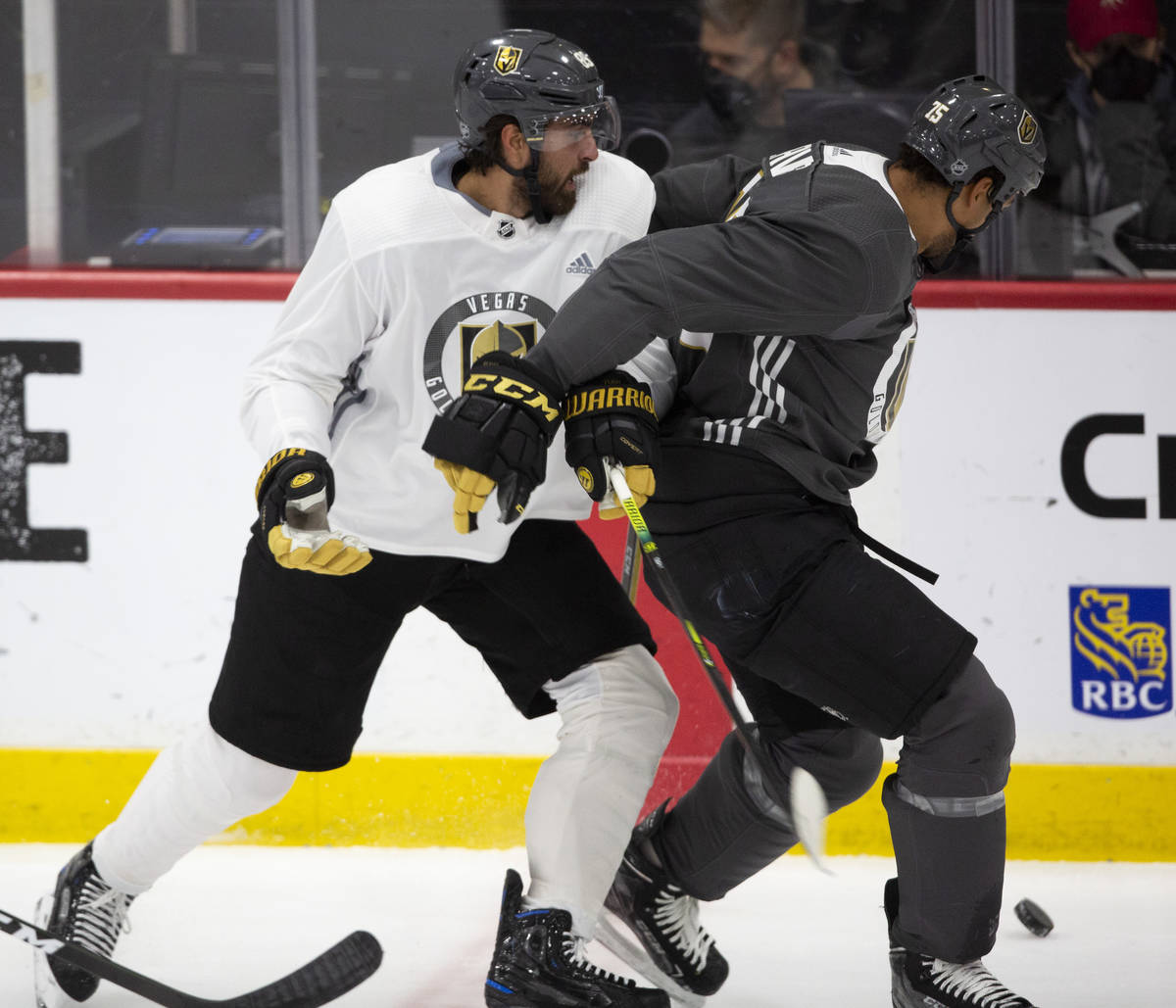 Golden Knights' forward Alex Tuch (89) and forward Ryan Reaves (75) fight for the puck during p ...