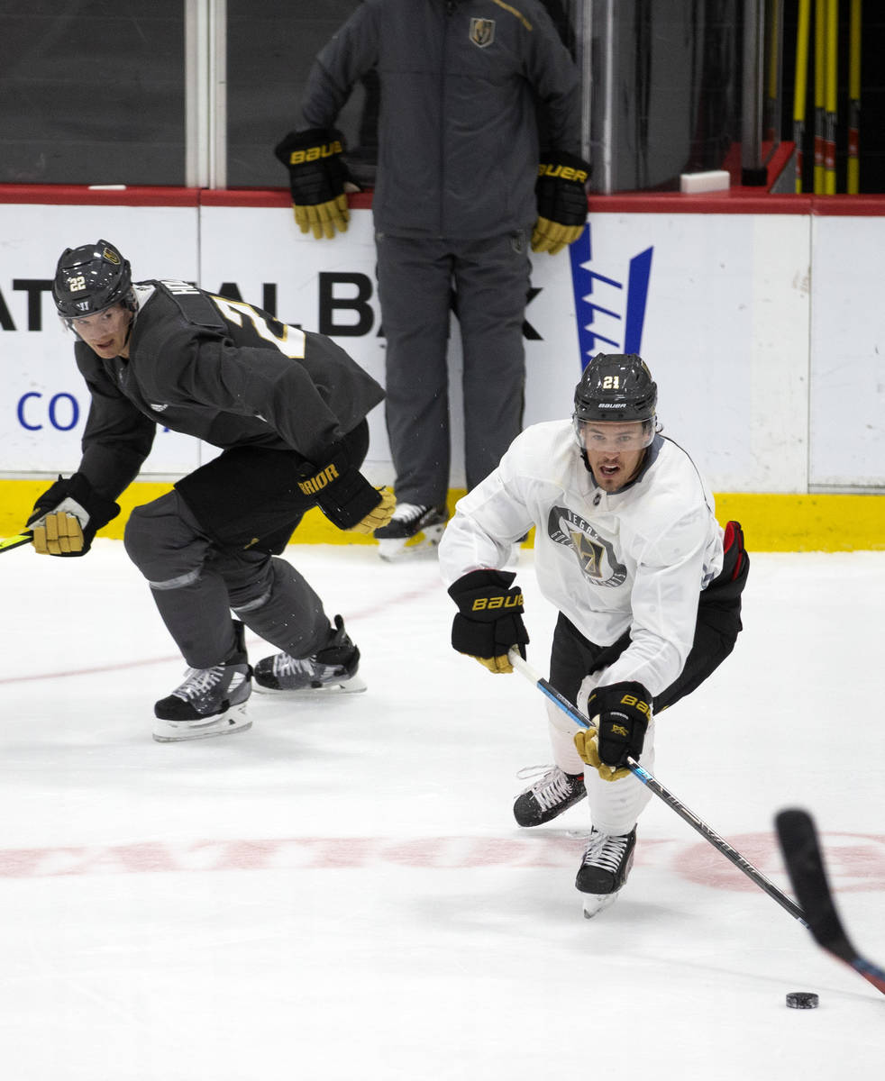 Golden Knights' forward Nick Cousins (21) reaches for the puck as defenseman Nick Holden (22) s ...