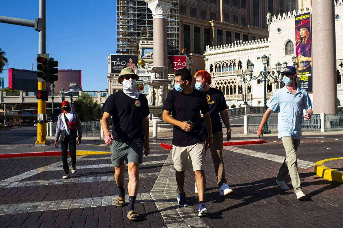 People wearing masks walk along the Las Vegas Strip on Friday, July 17, 2020. (Chase Stevens/La ...