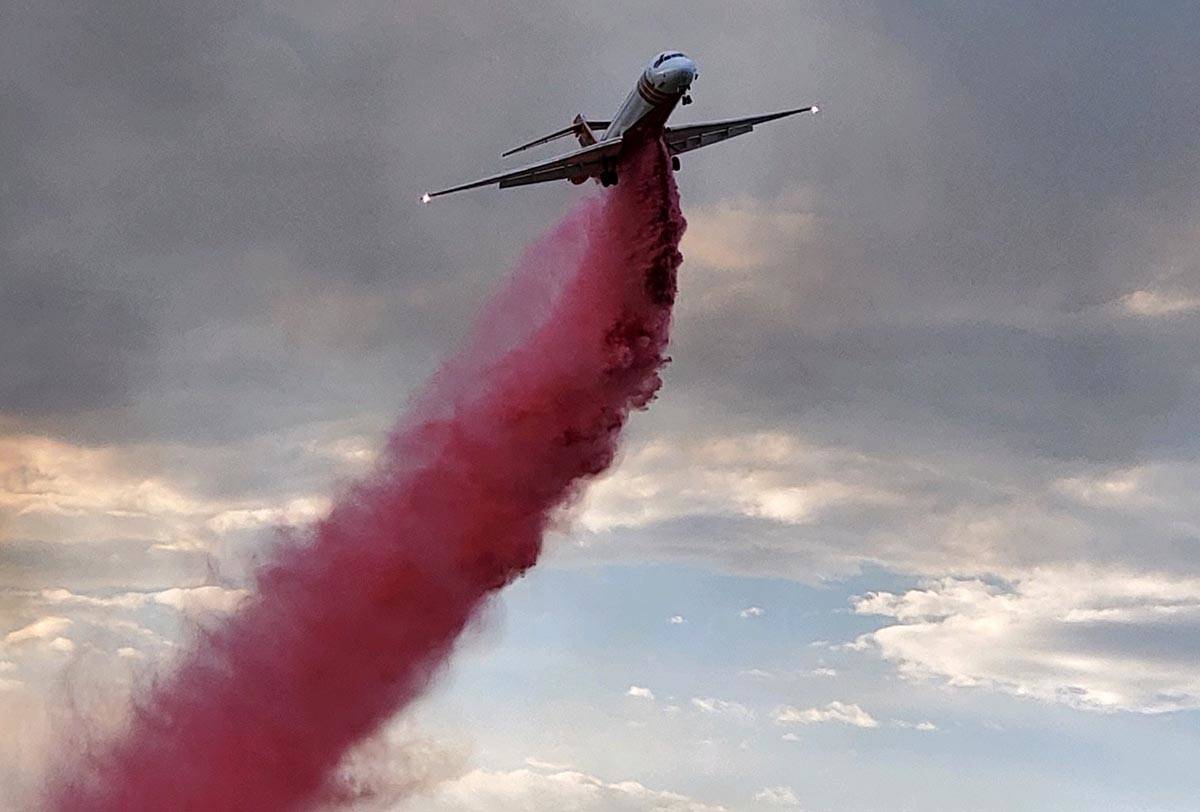 Fire retardant spills from an air tanker as crews battle the uncontained Cottonwood Fire southw ...