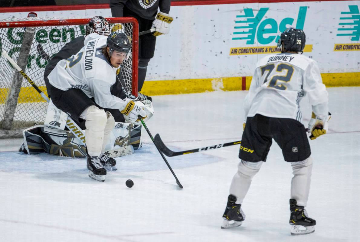 Vegas Golden Knights defenseman Zach Whitecloud (2, left) defends the net over forward Gage Qui ...