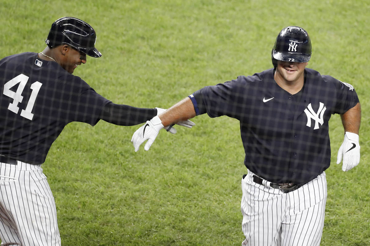 New York Yankees Miguel Andujar (41) congratulates Mike Ford after Ford hit a ninth-inning, sol ...