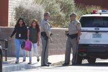 Students at Clark High School walk past Las Vegas police officers at their school Monday, Oct. ...
