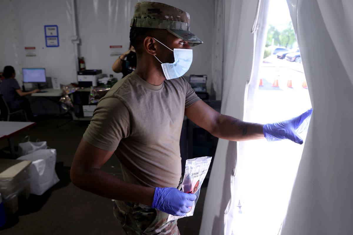 Nevada Air National Guard Airman 1st class Kevin Davis works on curbside testing for COVID-19 a ...