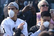 Fans during the Oakland Raiders vs. Los Angeles Chargers NFL game wear protective masks due to ...