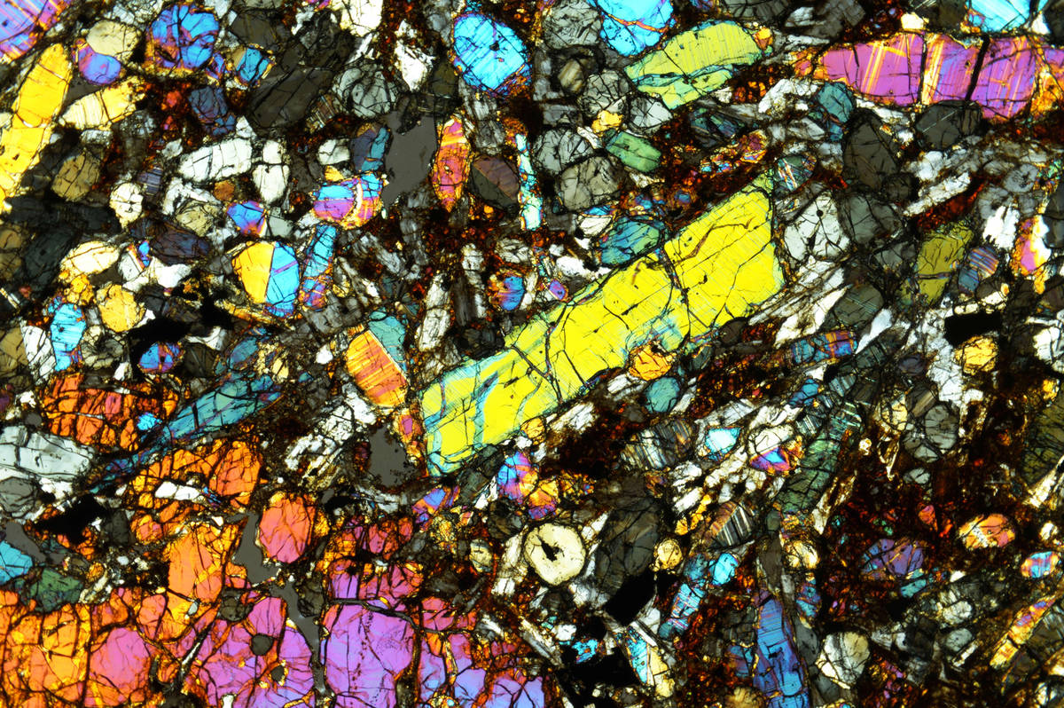 When viewed through polarized light in a microscope, a thin slice of meteorite reveals differen ...