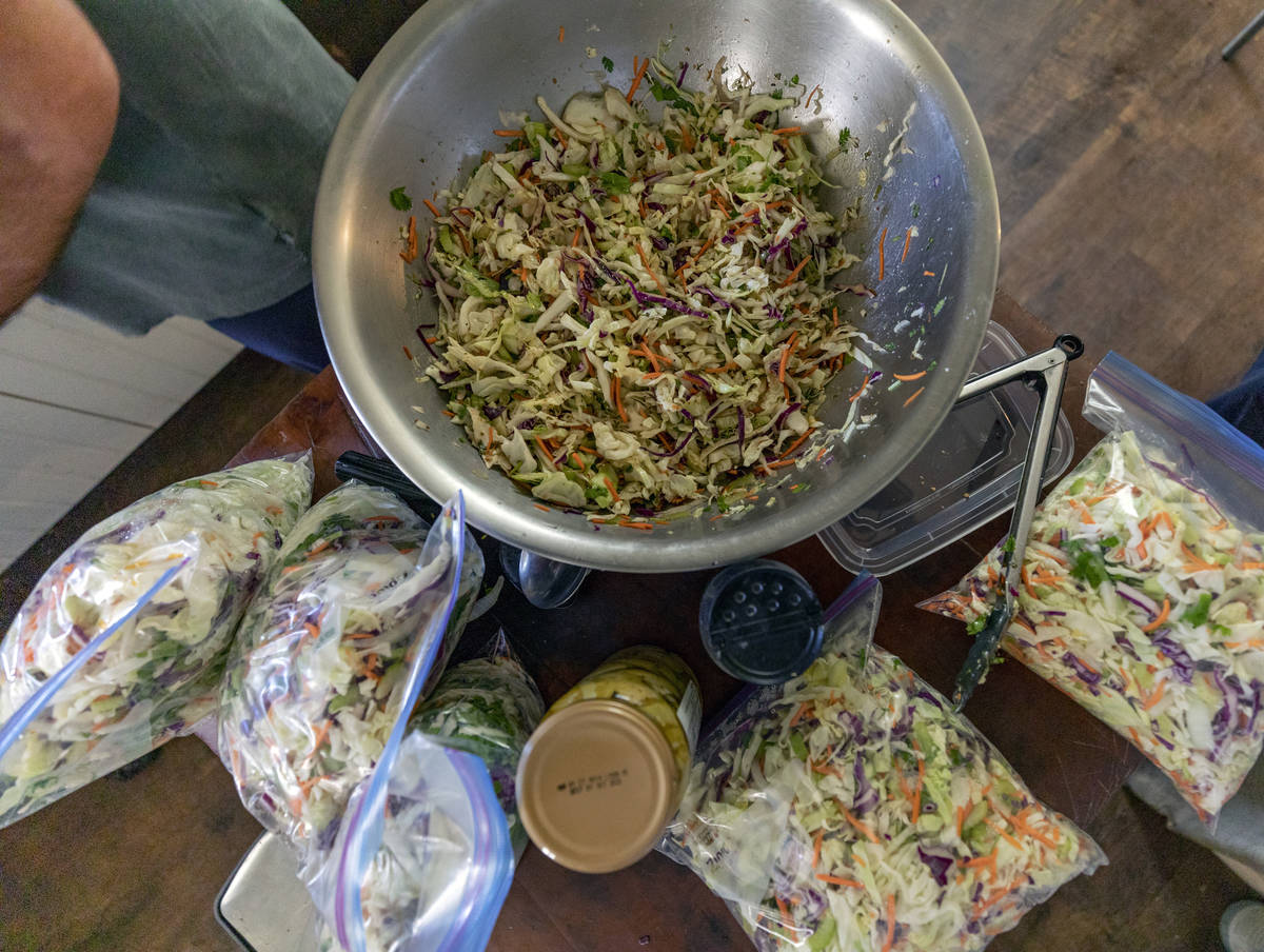 Food writer and lead organizer of Please Send Noodles Kim Foster prepares coleslaw for a side d ...