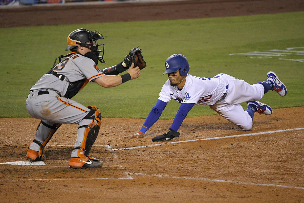 Los Angeles Dodgers' Mookie Betts, right, scores on a fielder's choice hit by Justin Turner as ...