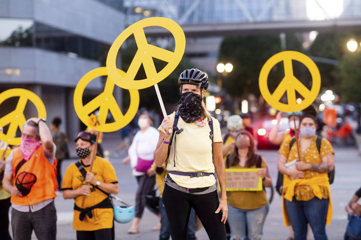 Mary Hubert, part of a "wall of moms," holds a peace sign during a Black Lives Matter ...
