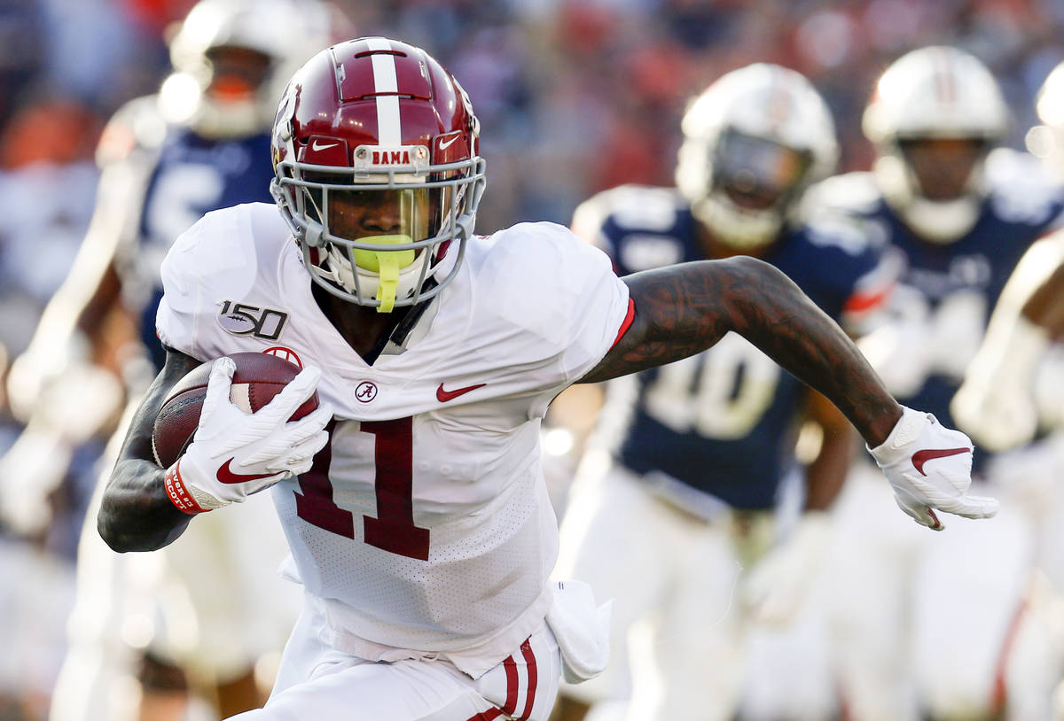Alabama wide receiver Henry Ruggs III (11) caries the ball against Auburn during an NCAA colleg ...