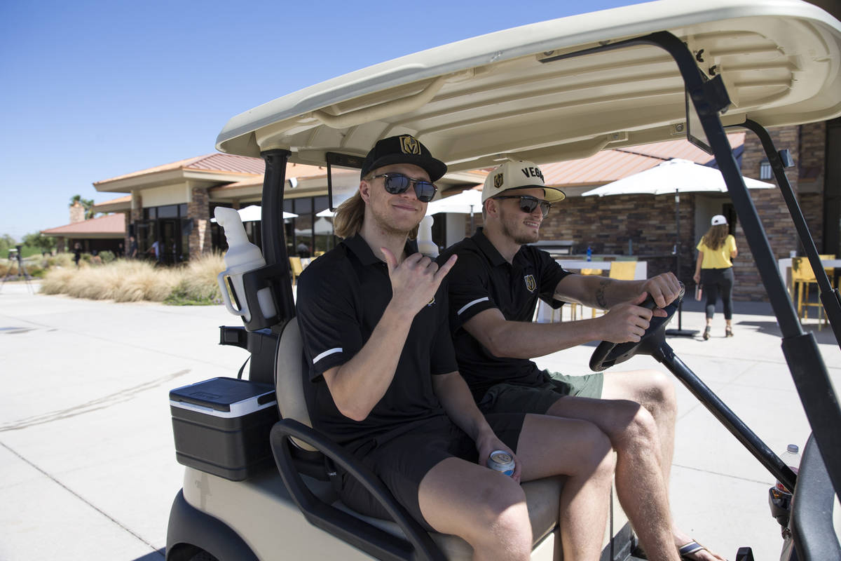 Vegas Golden Knights center William Karlsson, left, and goaltender Oscar Dansk (35) ride in a g ...