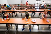 Children play with paint in the cafeteria during a summer camp at Legacy Traditional School in ...