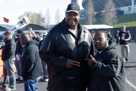 Former Oakland Raiders player Lincoln Kennedy, left, poses for photos with a fan at O.co Colise ...