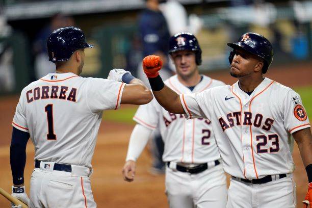 Houston Astros' Michael Brantley (23) celebrates with Carlos Correa (1) after hitting a three-r ...