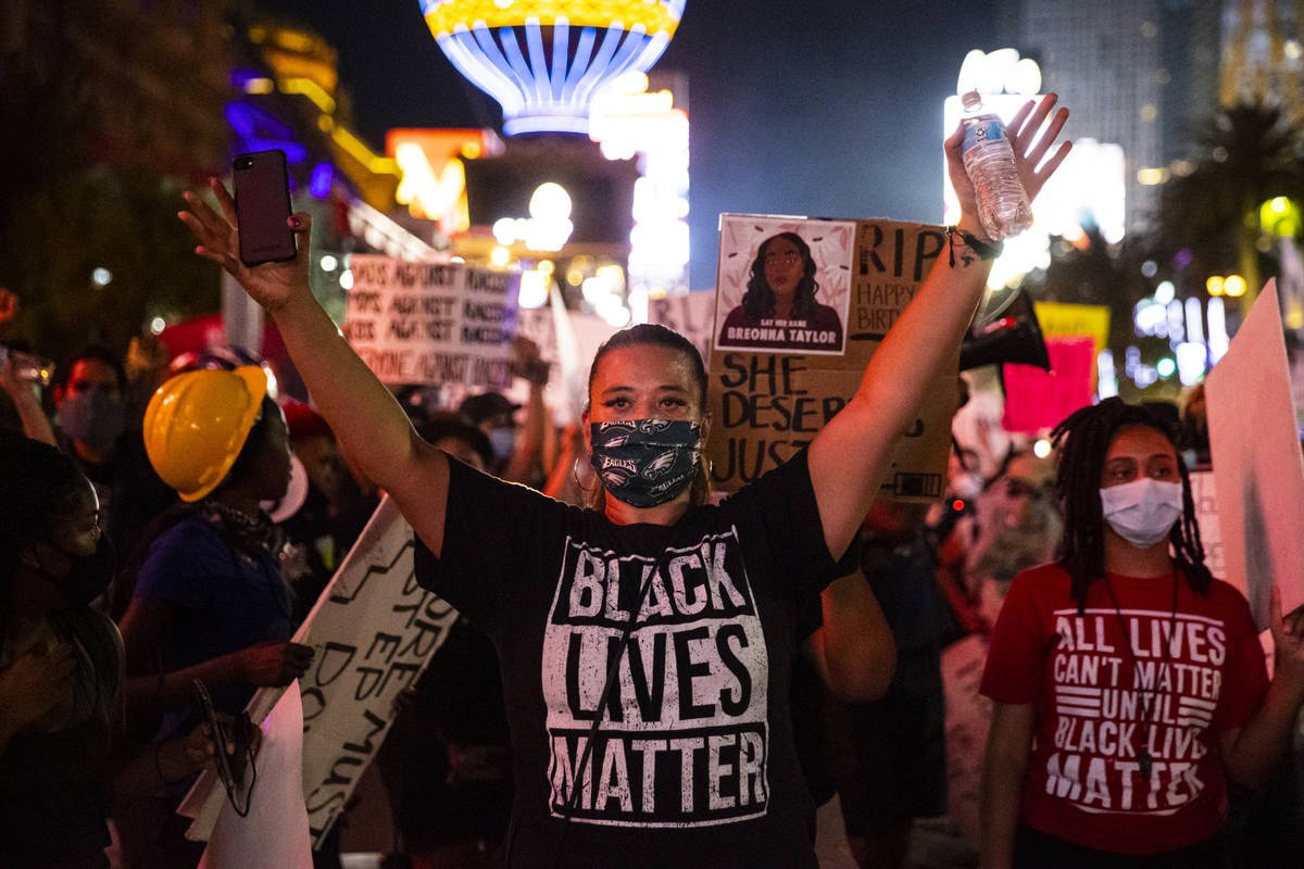 Leinati Hackley raises her hands during a Black Lives Matter march on the Las Vegas Strip on Sa ...