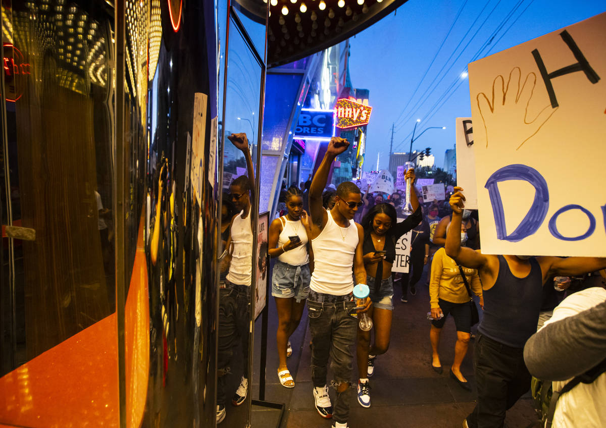 Tourists raise their fists in solidarity as people march during a Black Lives Matter rally on t ...