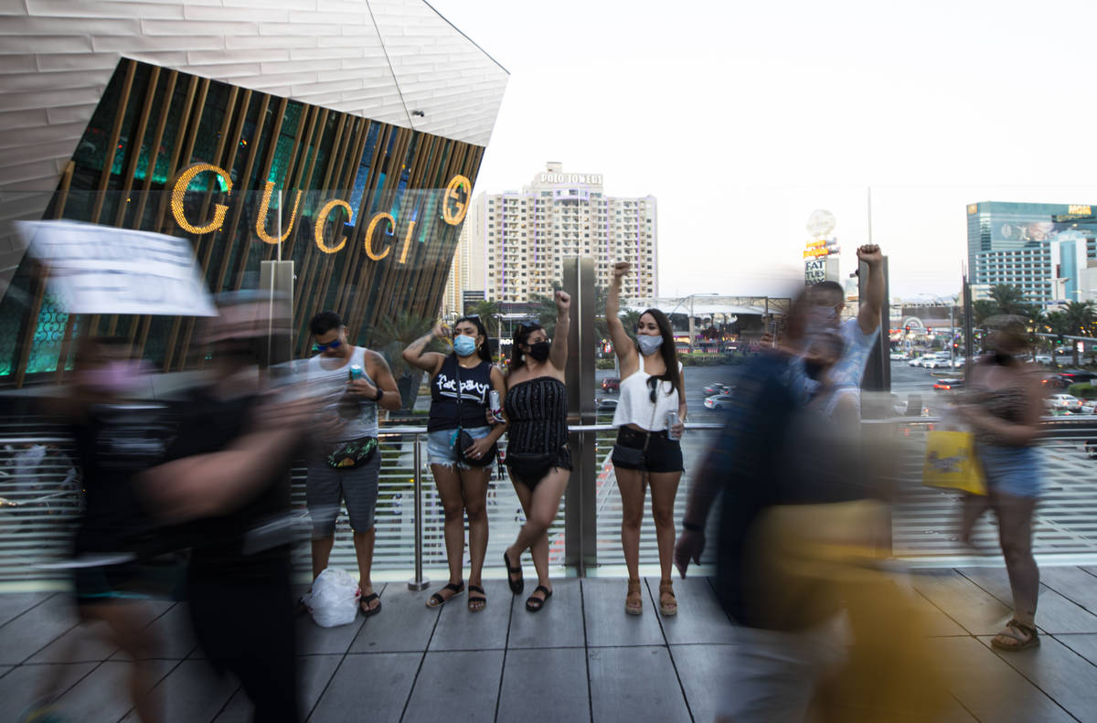 Tourists raise their fists in solidarity as people march during a Black Lives Matter rally on t ...