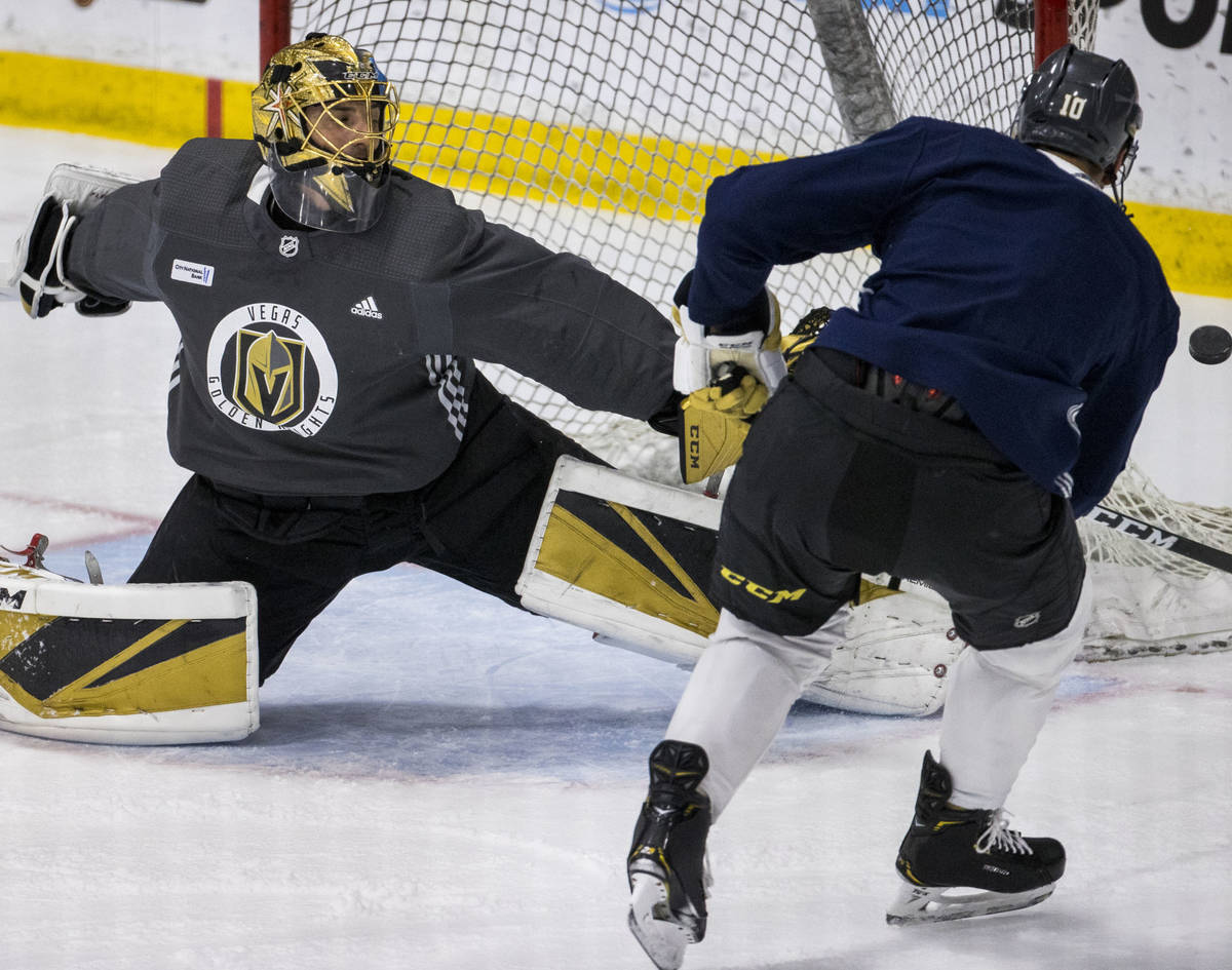 Vegas Golden Knights goaltender Marc-Andre Fleury (29, left) deflects away a shot by center Nic ...