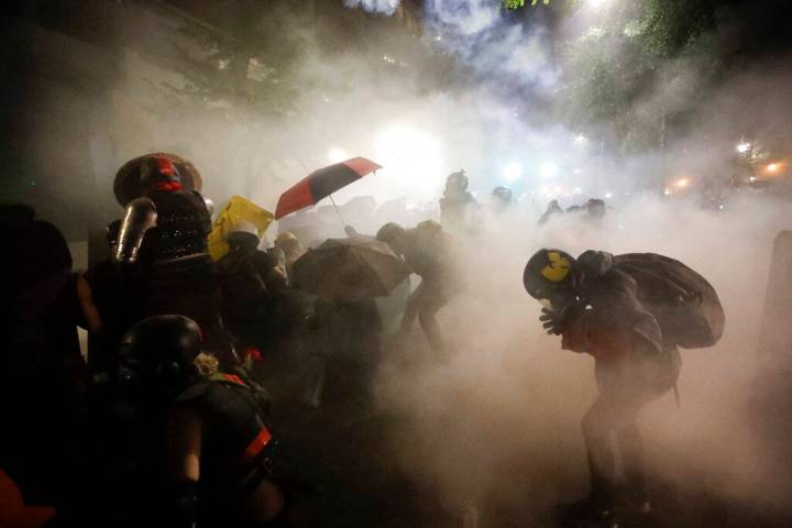 Federal officers launch tear gas at a group of demonstrators during a Black Lives Matter protes ...